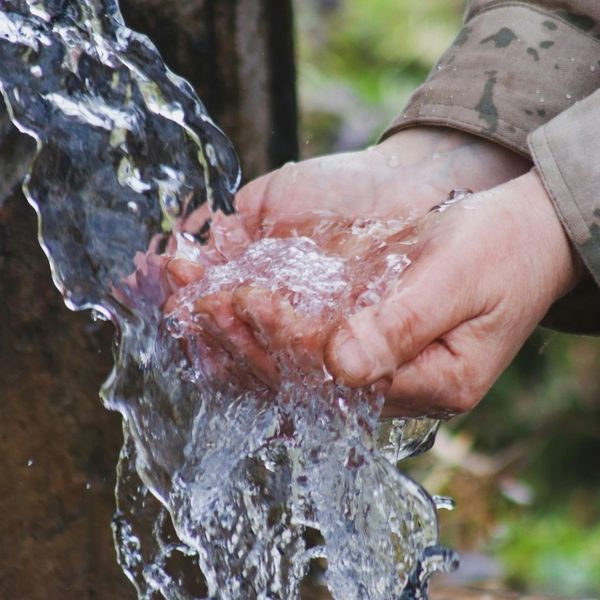 man washing hands outside