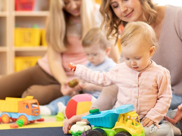 wo child care professionals playing with two babies