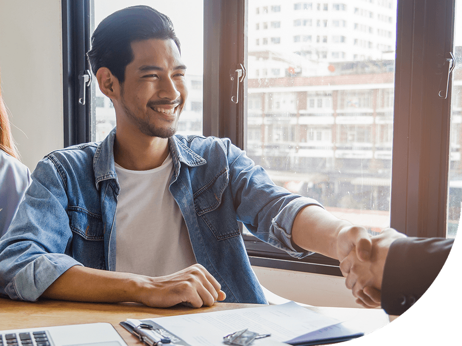 Man shaking hand across desk