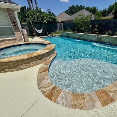 Newly built swimming pool and raised stone spa in Spring, TX completed by Express Pool Plastering and Repairs