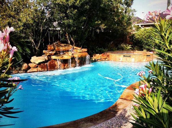 Freeform Houston pool with a rock waterfall and tropical planting