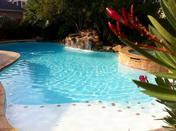Freeform Houston pool with a rock waterfall and tropical planting beds
