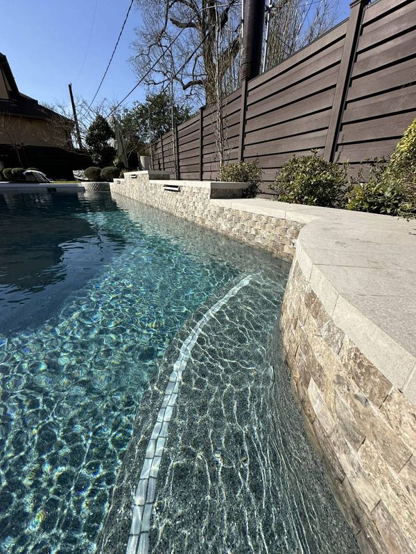 Pool coping and waterline edge spilling into a lower pool in Houston