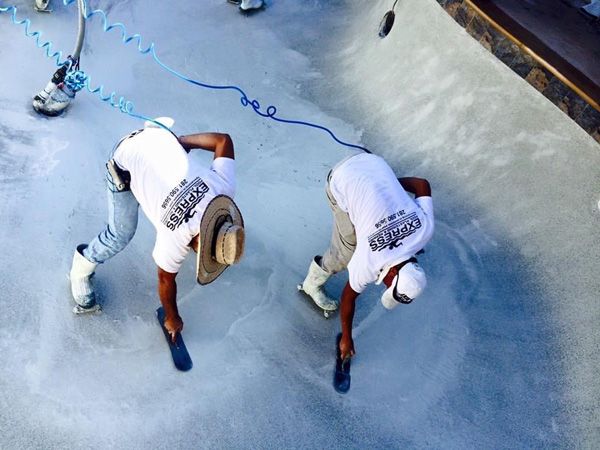 Express Pool Plastering crew troweling fresh plaster in a drained Houston pool