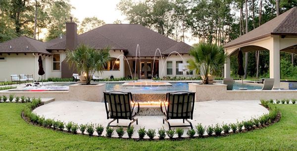 Large Houston home with a pool, deck fountains and a fire pit seating area