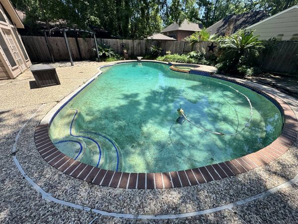 Houston pool at a full water level with brick coping