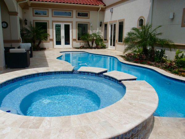 Houston pool with a raised round spa beside a stucco home
