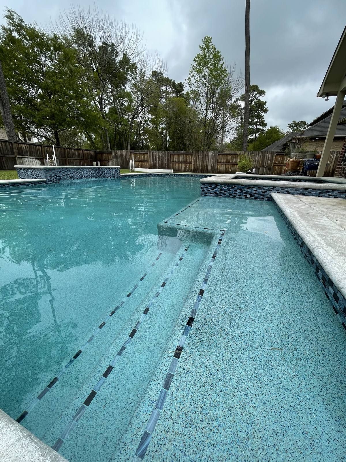 Repaired and refinished Houston pool with tiled entry steps