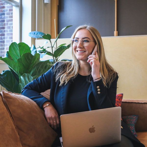 Person on the phone with a laptop in front of her