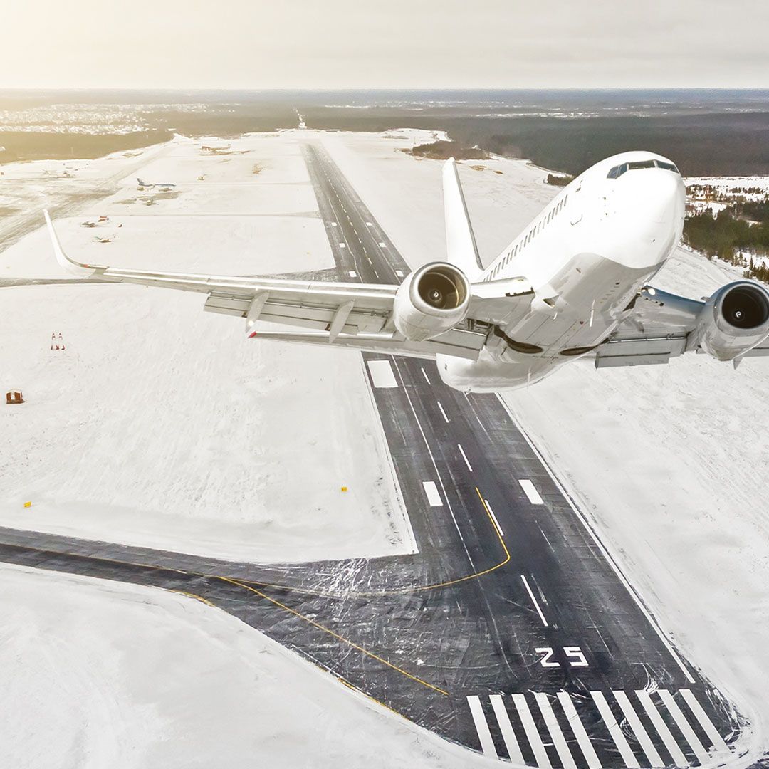 Airplane is climbing flight level high view in the air, against the background of the winter airport of the runway, city, snow, forests, and roads