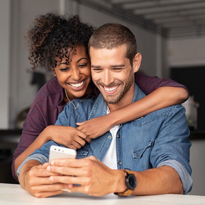 smiling couple using a mobile phone