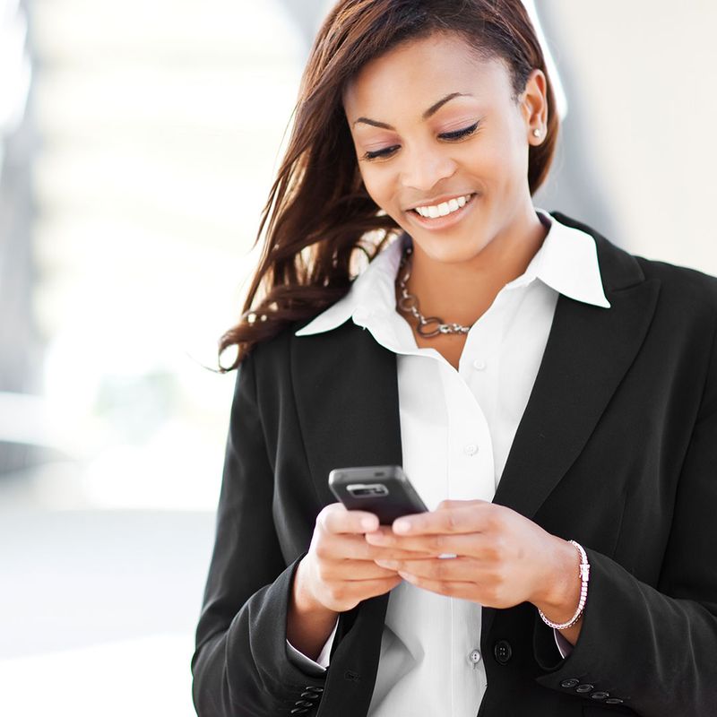 A shot of a beautiful black businesswoman texting