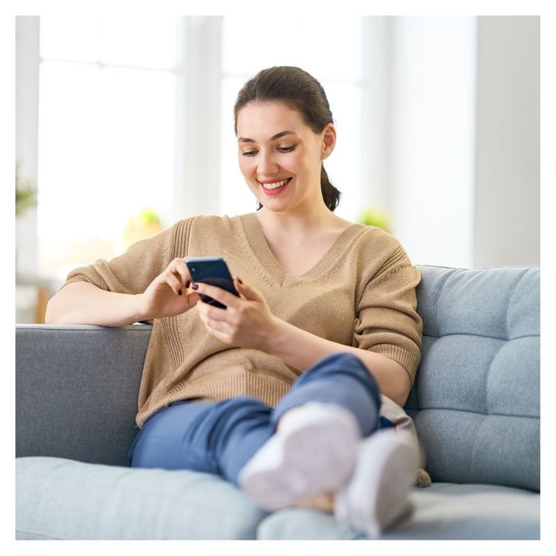 woman smiling scrolling on cell phone