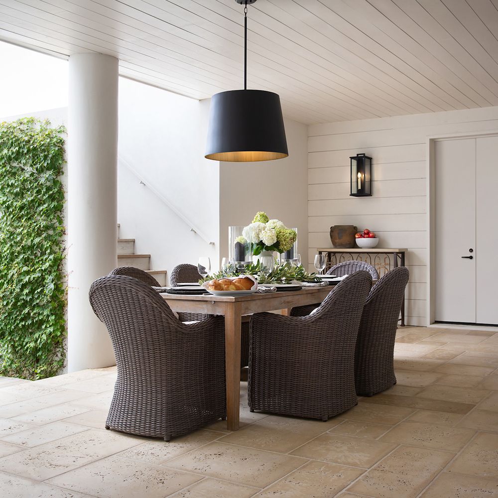 A modern black drum chandelier over an outdoor table