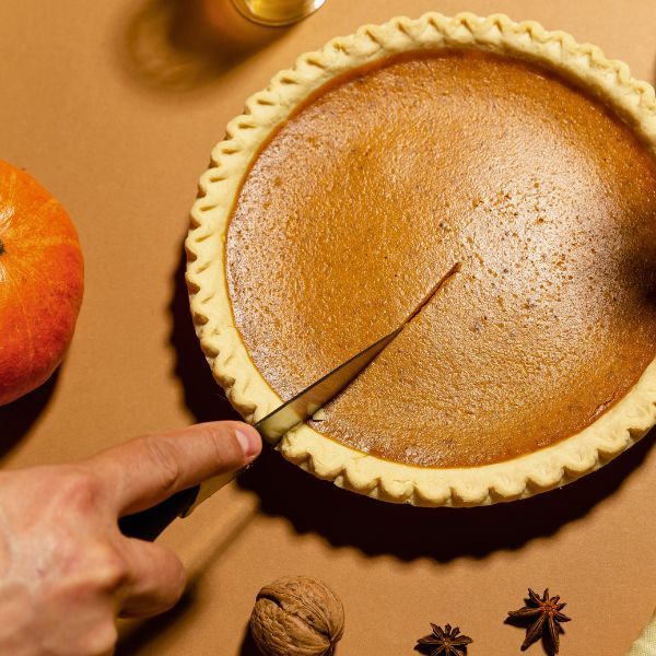 cutting into pumpkin pie