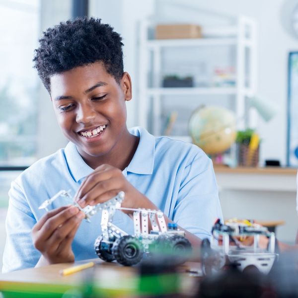 middle-school aged kid working on building model cars