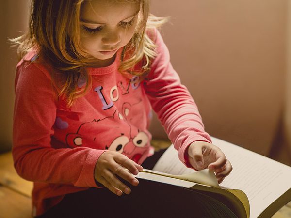 A toddler reading a book.