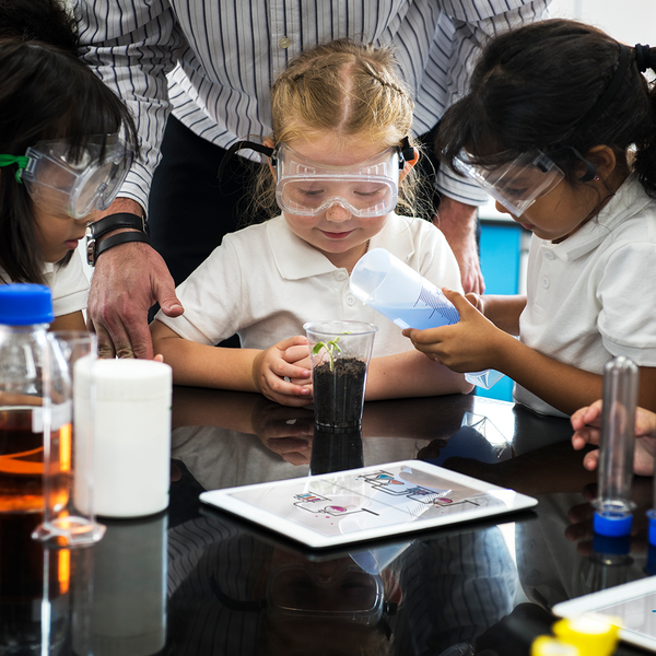 Young children wearing goggles while doing a science experiment