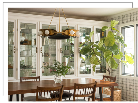 dining room with glass cabinets, tall plant, and unique chandelier