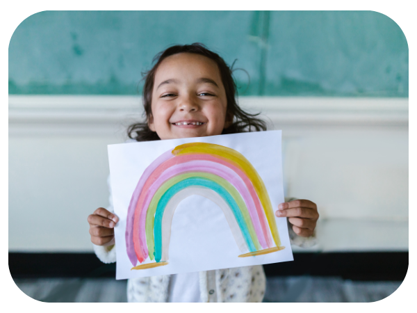 child holding a rainbow picture 