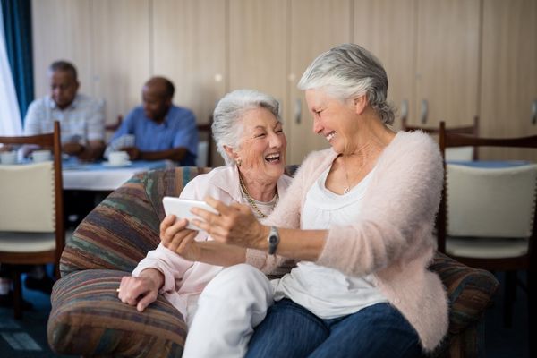 seniors looking at phone together seniors looking at phone together