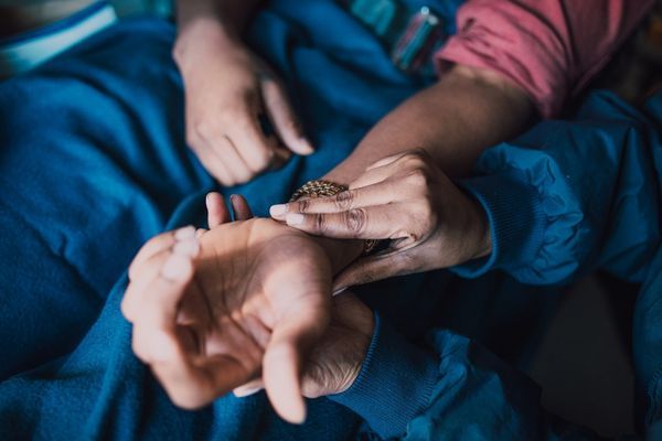 nurse takes pulse from person's wrist