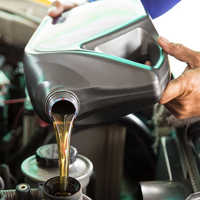 Mechanic pouring oil into an engine