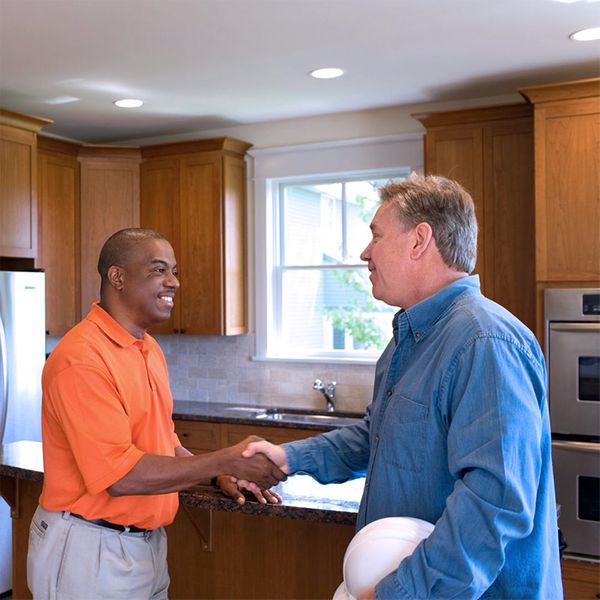 Two men handshake in a house