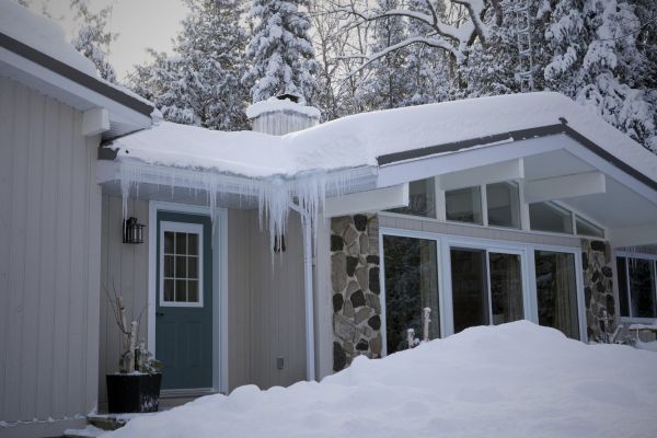 House with an ice dam and snow on the roof