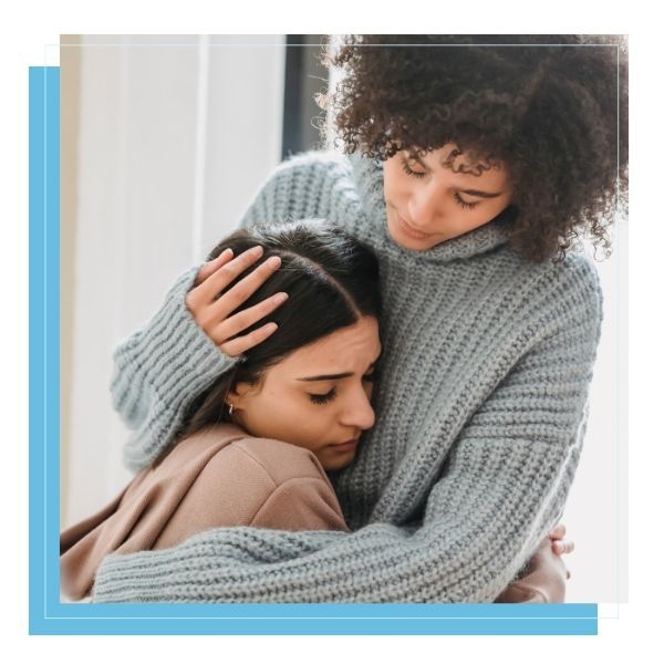 woman in emotional pain receiving hug from friend woman in emotional pain receiving hug from friend