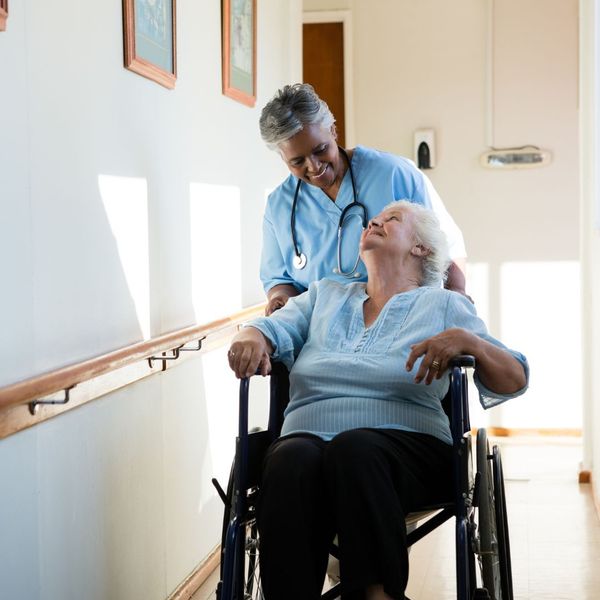 A nurse pushing a patient in a wheelchair.