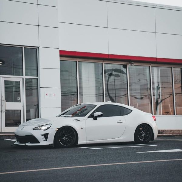 A sleek, white car parked in front of a dealership