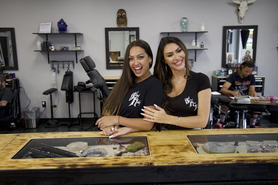 Two beautiful women employees of Sacred Raven Tattoo