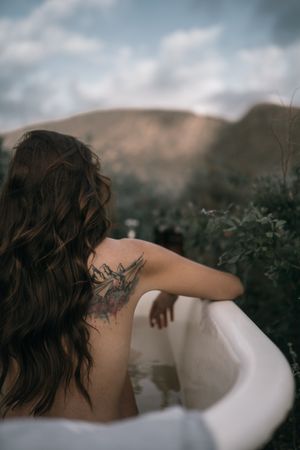 woman in bathtuv with tattoo out of water.jpg