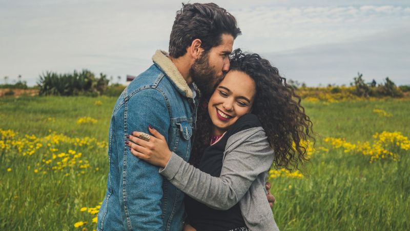 man and woman in field hugging man and woman in field hugging