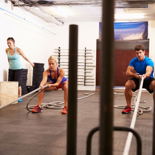 a group of people pulling weights and doing box jumps for exercise