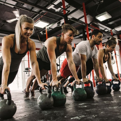 a group of people planking on kettle bells during a workout