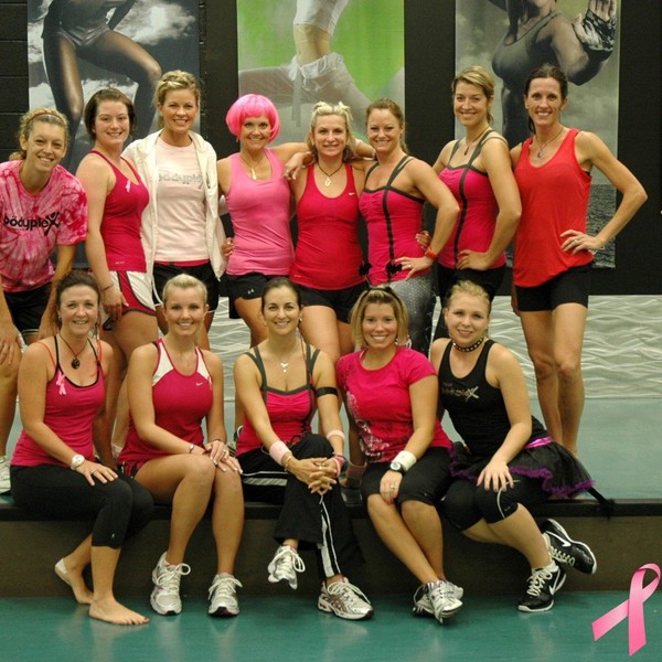 a group of women dressed in pink exercise clothes for breast cancer awareness