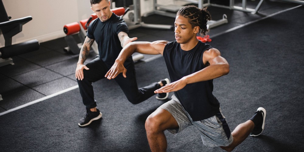 two men working out, one a personal trainer