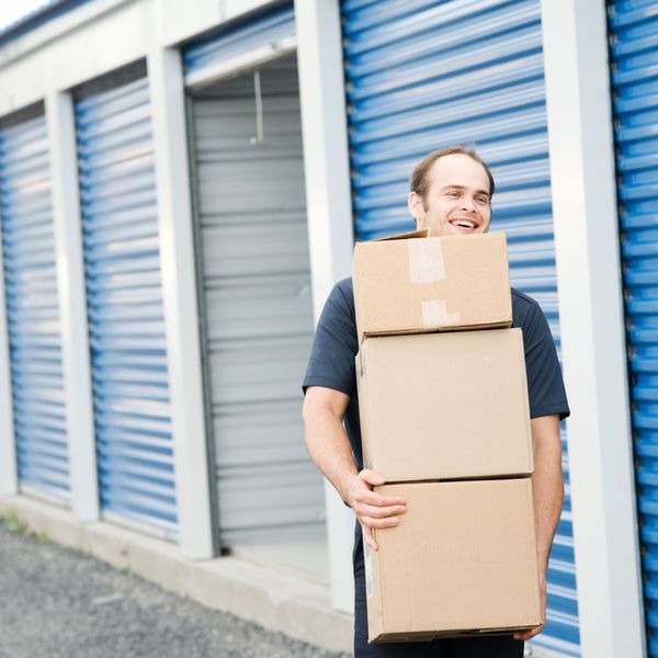 man carrying boxes to his storage container