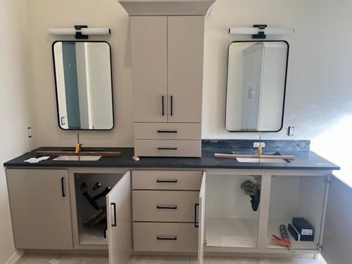 Luxury master bathroom remodel featuring a long grey double vanity with black quartz countertops, a large integrated LED backlit mirror, and warm lighting. Modern Bathroom Dual Vanity Design