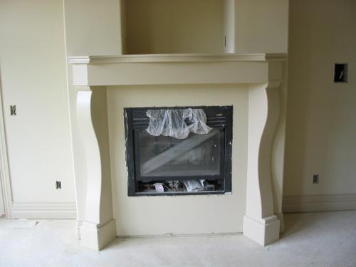 New home construction with a built-in fireplace, mantel, and an empty recess for a television. New home construction with a built-in fireplace, mantel