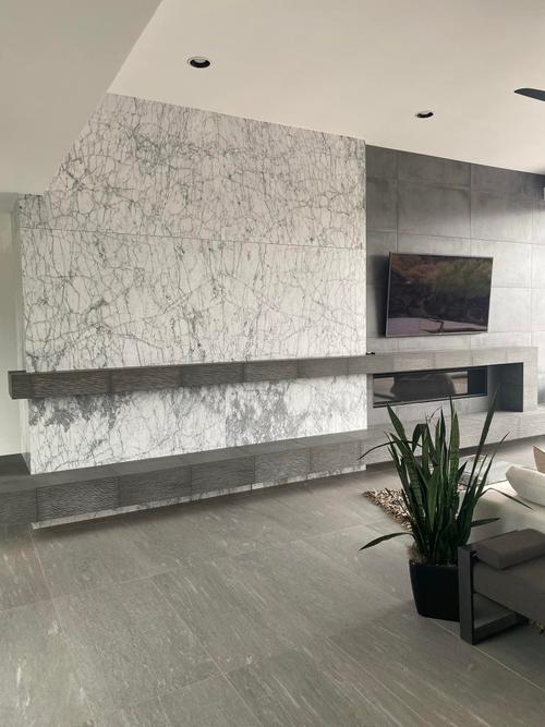 A modern living room with a custom tile fireplace wall, a floating hearth, and a linear fireplace. Custom Fireplace