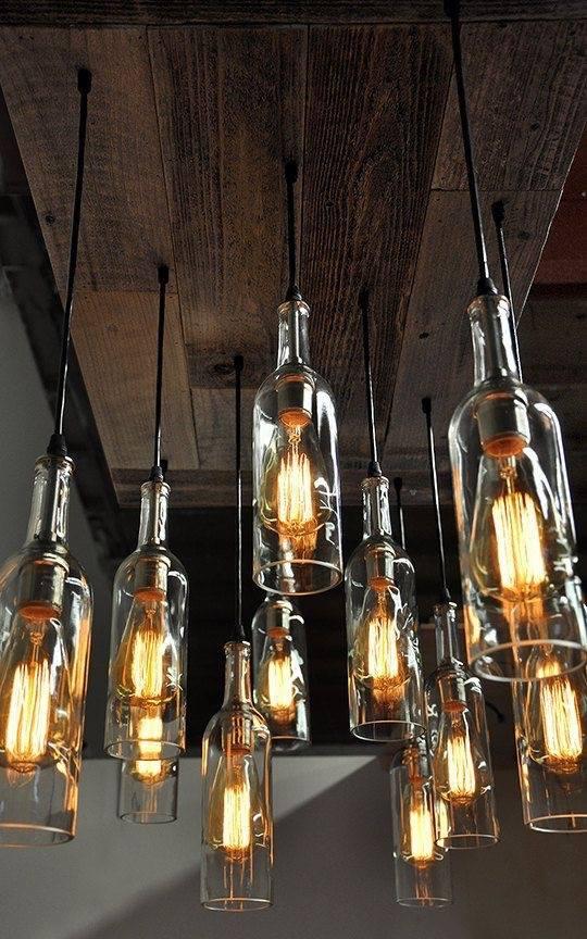 Custom light fixtures made from wine bottles in a rustic-style home, adding unique character to the space. Custom light fixtures made from wine bottles in a rustic-style home