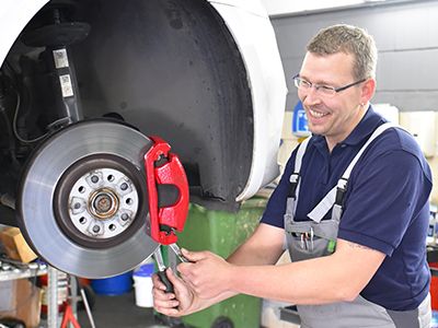 an image of technician working on brakes