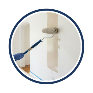 A paint roller applying a light brown paint to white walls
