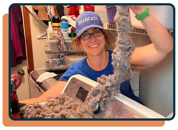woman pulling lint out of a dryer vent