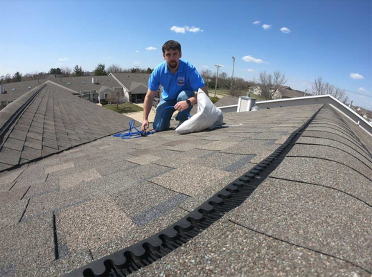 man on roof repairing dryer vent