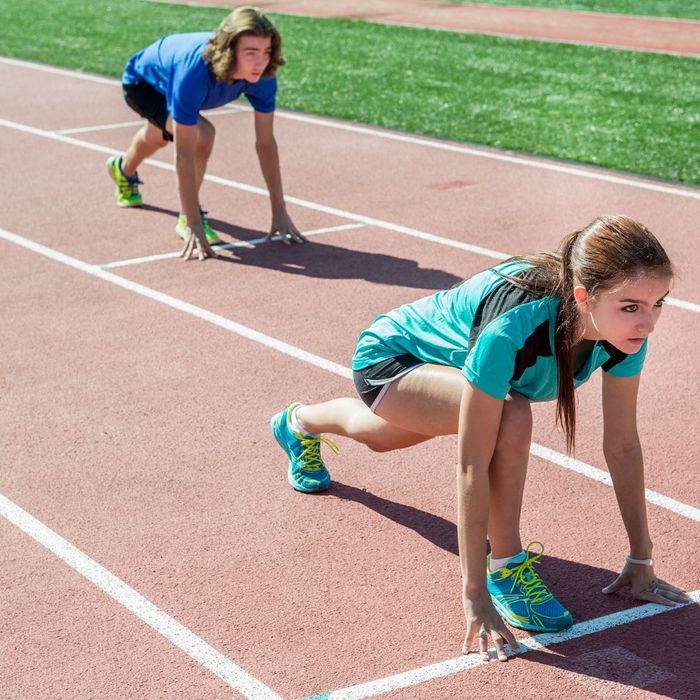 Two teen track athletes in starting position