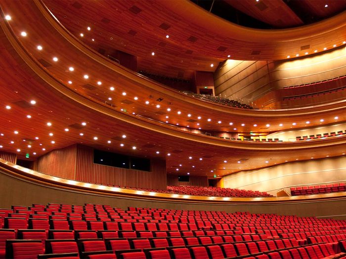 A large auditorium with red seats